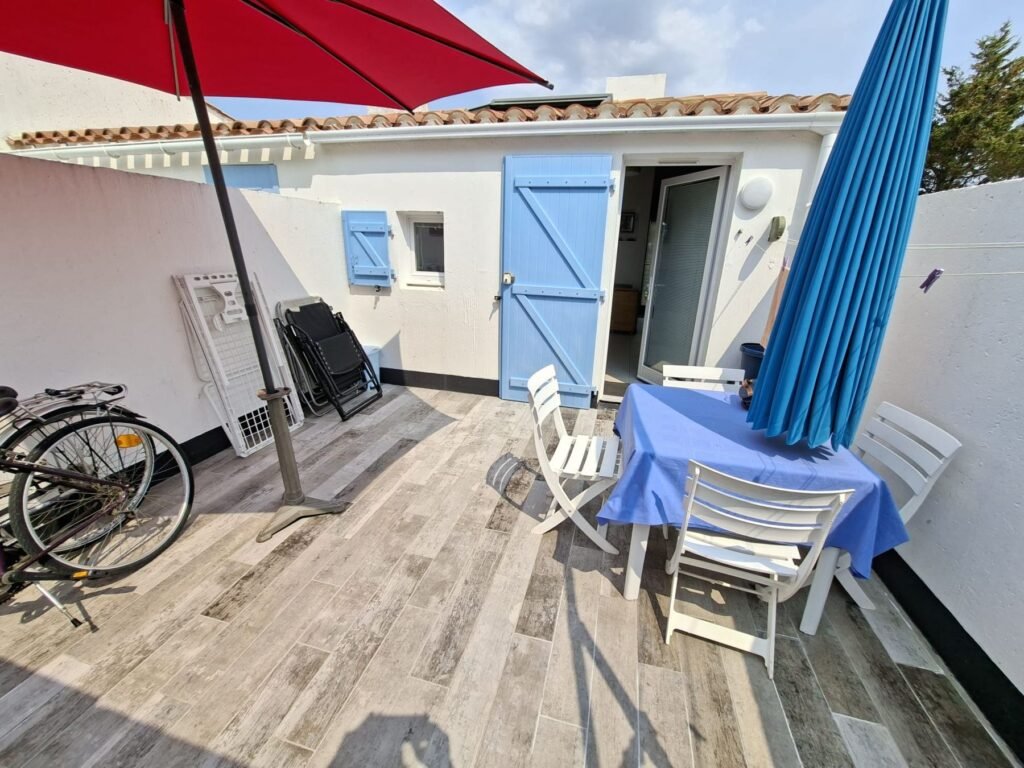 Patio privé du studio avec table, chaises et parasol : location studio Brétignolles-sur-Mer
