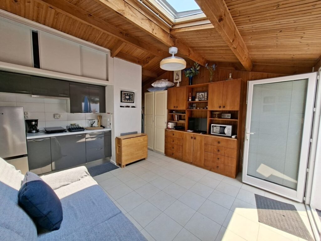 Photos studio Brétignolles-sur-Mer : vue d'ensemble avec kitchenette, grand meuble en bois et porte-fenêtre