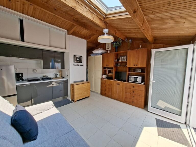 Photos studio Brétignolles-sur-Mer : vue d'ensemble avec kitchenette, grand meuble en bois et porte-fenêtre